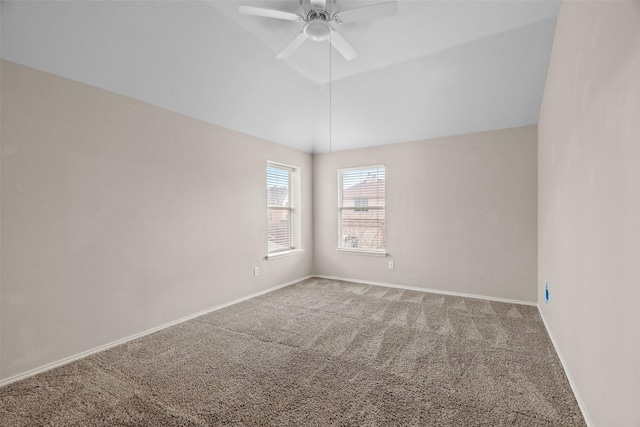 carpeted spare room featuring lofted ceiling, ceiling fan, and baseboards