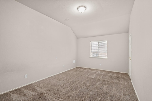 unfurnished room featuring lofted ceiling, carpet floors, and baseboards