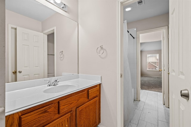 bathroom with marble finish floor, a shower with curtain, visible vents, and vanity