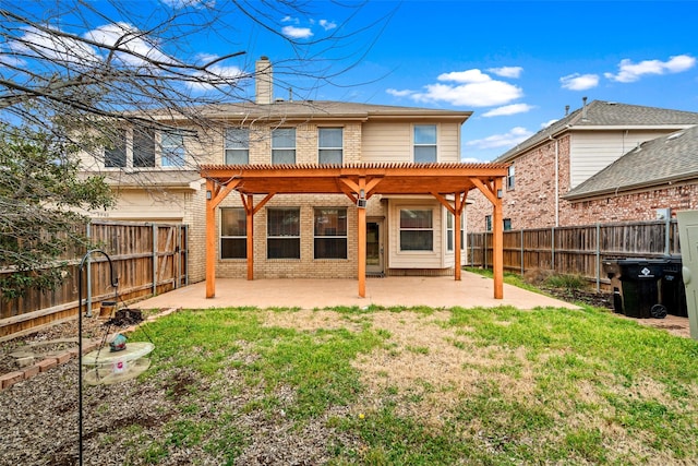 rear view of property with brick siding, a lawn, a pergola, a chimney, and a patio area