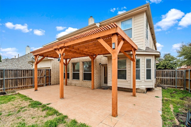 rear view of house with brick siding, a chimney, a patio area, and a pergola