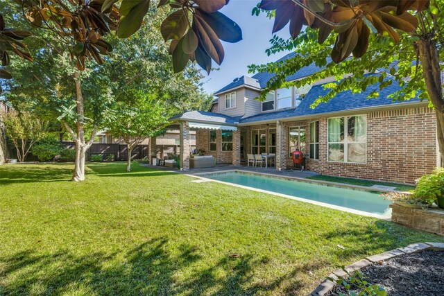 back of house with a patio area, fence, brick siding, a chimney, and a lawn