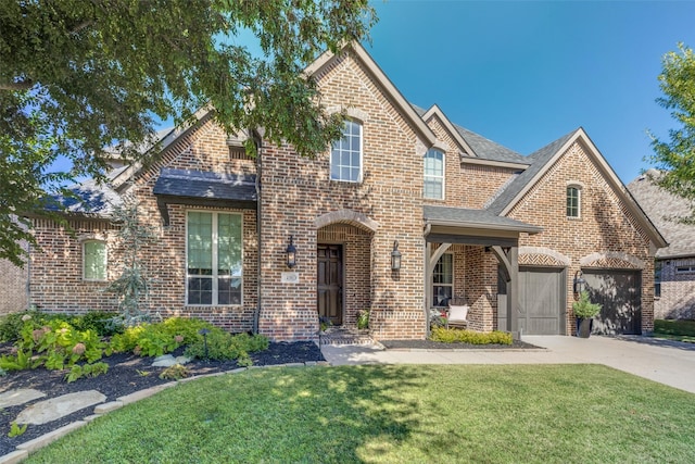traditional-style house with a garage, concrete driveway, a shingled roof, a front lawn, and brick siding