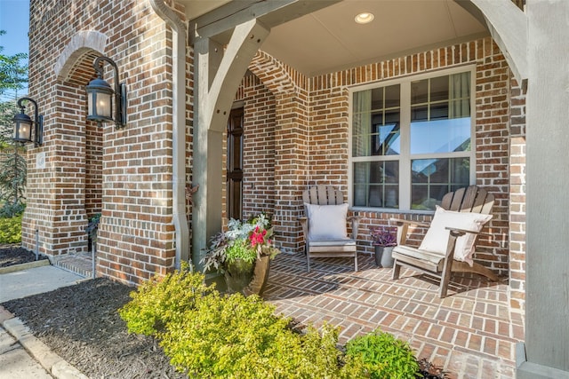 property entrance with covered porch and brick siding