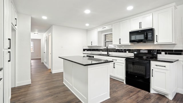 kitchen with dark countertops, black appliances, backsplash, and a sink