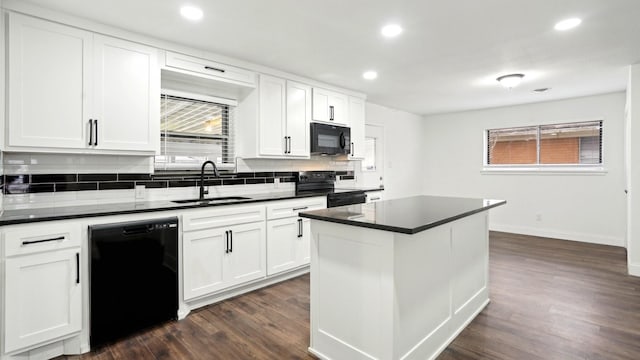 kitchen with dark countertops, black appliances, dark wood-type flooring, and a sink