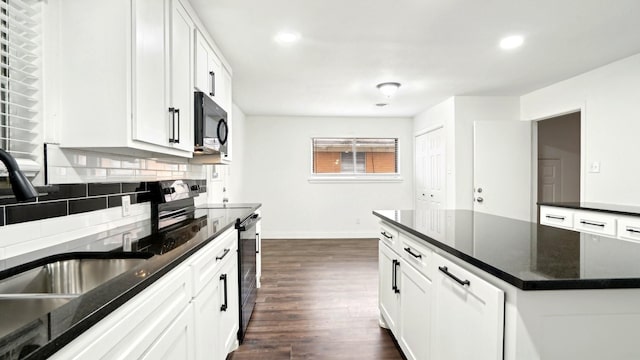 kitchen featuring dark wood-style floors, backsplash, white cabinets, a sink, and baseboards