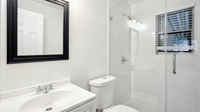 bathroom featuring a stall shower, vanity, and toilet