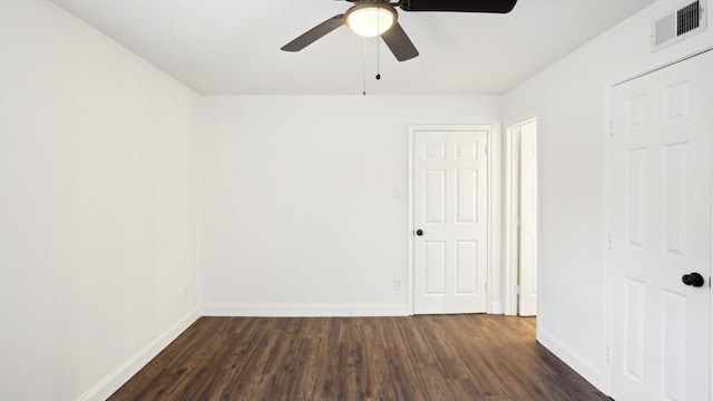 spare room featuring ceiling fan, dark wood-type flooring, visible vents, and baseboards