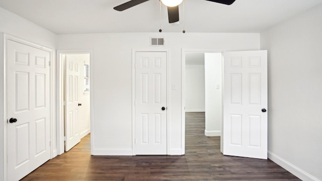 unfurnished bedroom with visible vents, dark wood finished floors, and baseboards