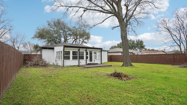 back of property with a fenced backyard and a yard