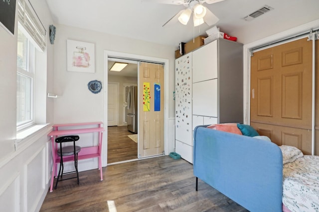 interior space featuring ceiling fan, visible vents, wood finished floors, and freestanding refrigerator