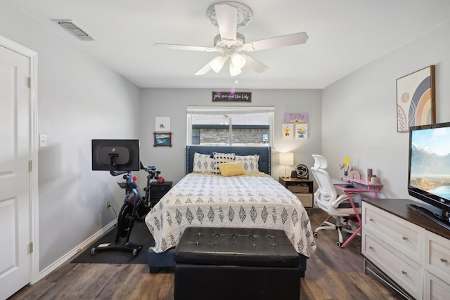 bedroom with dark wood-style floors, ceiling fan, visible vents, and baseboards