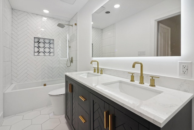 bathroom with double vanity, tub / shower combination, a sink, and toilet