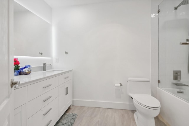 full bath featuring shower / bathtub combination, toilet, vanity, wood finished floors, and baseboards