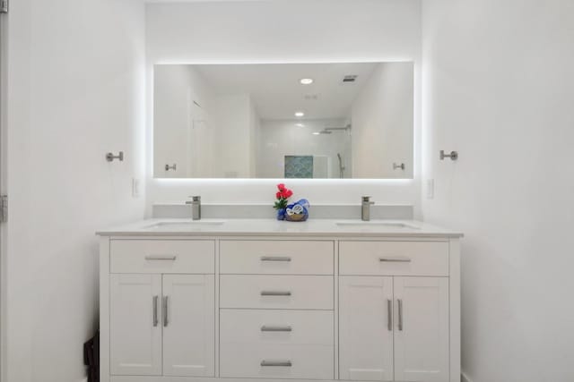 full bath featuring double vanity, visible vents, a shower, and a sink