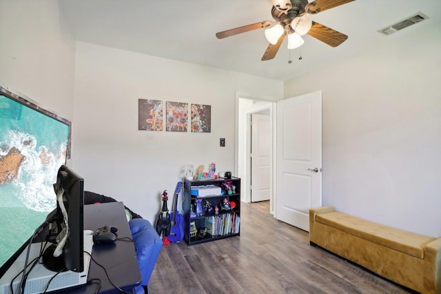 office area with a ceiling fan, visible vents, and wood finished floors