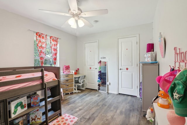 bedroom featuring a ceiling fan, baseboards, and wood finished floors