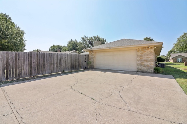 exterior space featuring a garage, fence, and brick siding