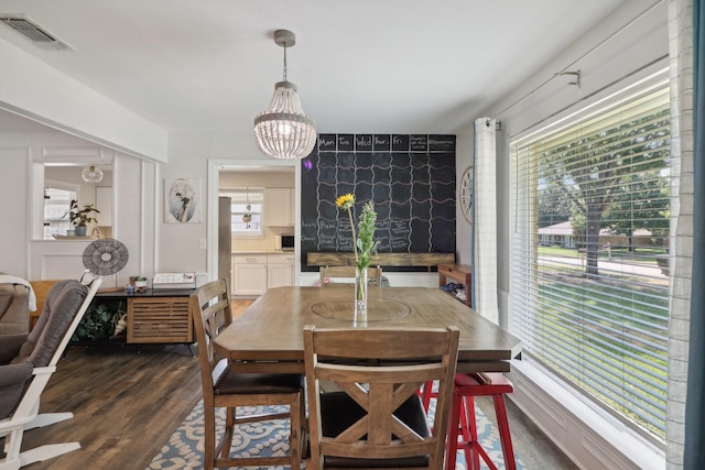 dining room with a healthy amount of sunlight, an inviting chandelier, visible vents, and dark wood-style flooring