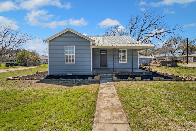 view of front of property with a front lawn, covered porch, and metal roof