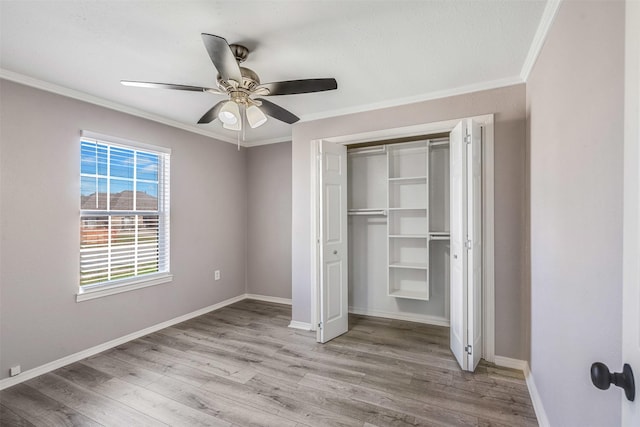 unfurnished bedroom featuring wood finished floors, baseboards, and ornamental molding