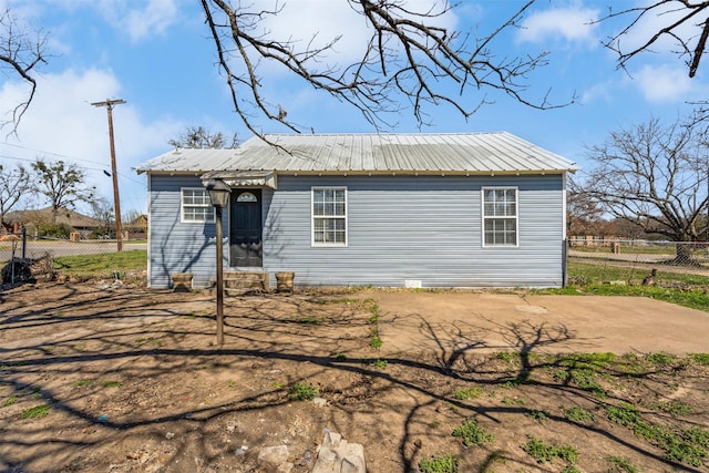 view of front of property with metal roof and fence