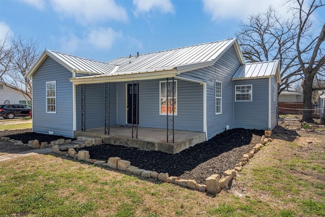 view of front of house featuring a front yard, a patio area, fence, and metal roof