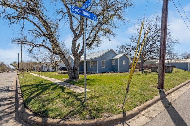 view of front of house featuring metal roof, a front yard, and fence