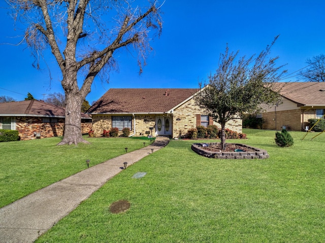 single story home featuring brick siding and a front lawn