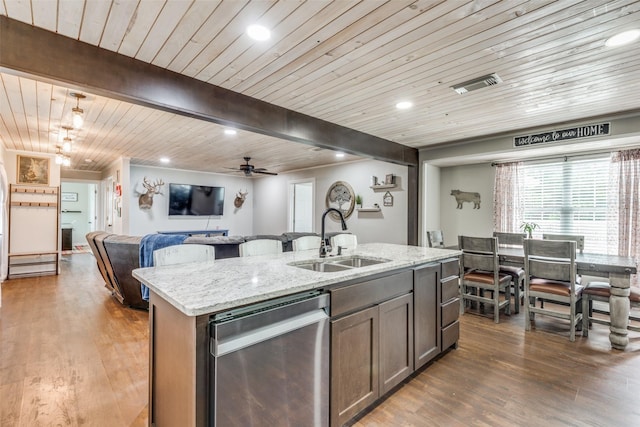 kitchen featuring a center island with sink, visible vents, open floor plan, a sink, and dishwasher