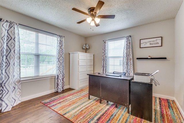 office area with a textured ceiling, wood finished floors, a ceiling fan, and baseboards