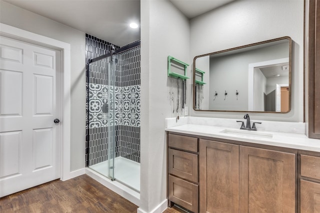 bathroom featuring a stall shower, wood finished floors, and vanity