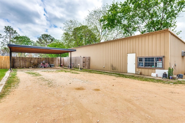 view of outdoor structure featuring dirt driveway and fence