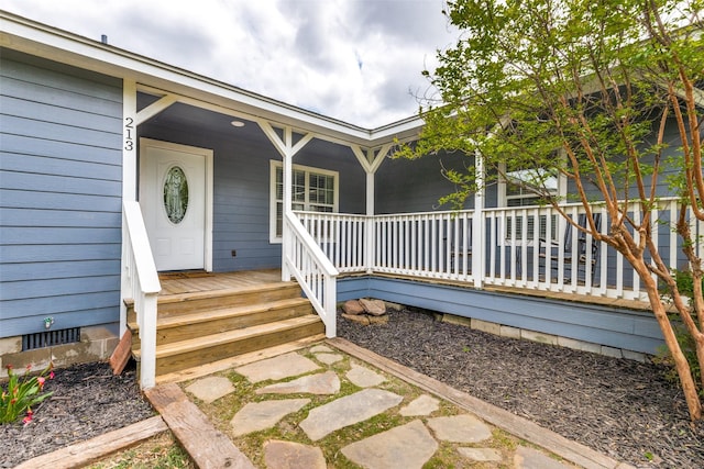 entrance to property featuring covered porch and crawl space