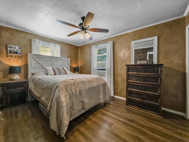 bedroom with multiple windows, crown molding, baseboards, and wood finished floors