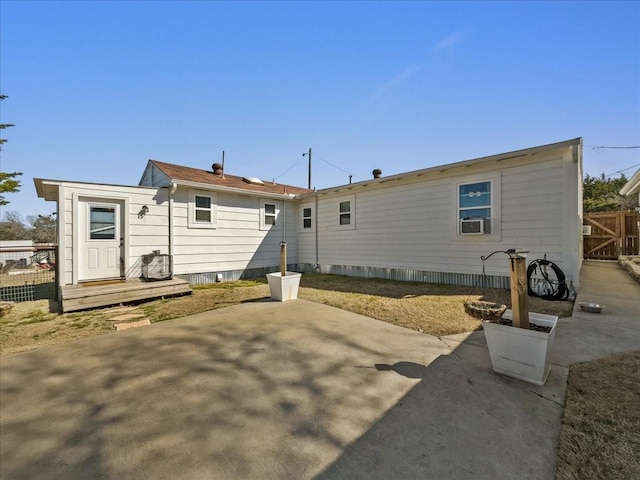 back of property with cooling unit, fence, and a patio