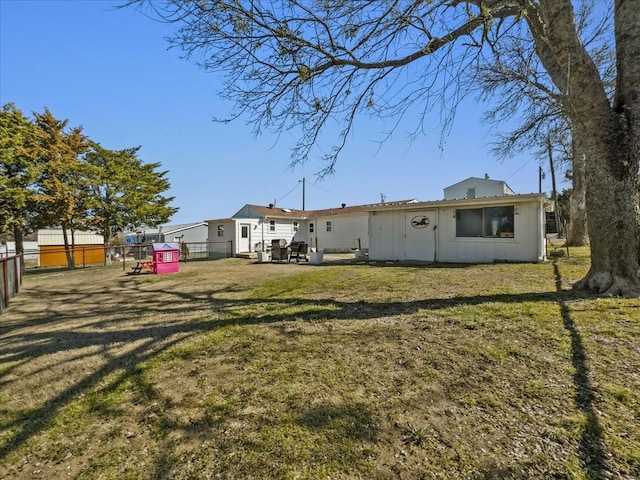 rear view of property featuring a yard, a patio, and fence