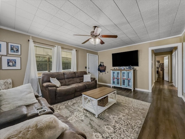 living area with ornamental molding, ceiling fan, baseboards, and dark wood-style floors