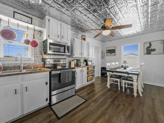 kitchen with stainless steel appliances, dark wood-type flooring, a sink, backsplash, and an ornate ceiling