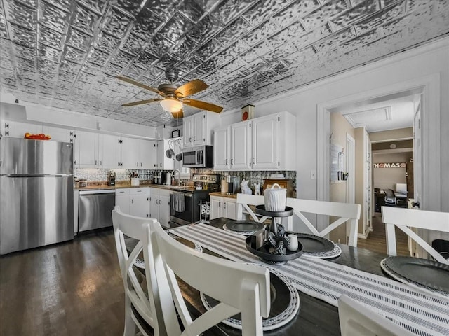 kitchen featuring tasteful backsplash, white cabinets, an ornate ceiling, stainless steel appliances, and a sink