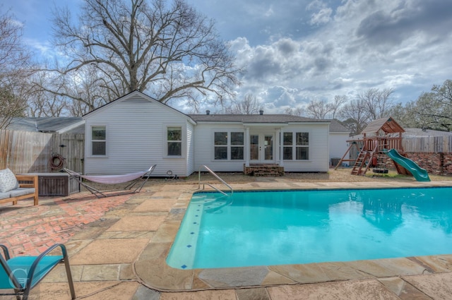 view of pool with a fenced in pool, french doors, a playground, a patio, and fence