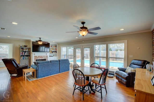 dining area with french doors, light wood-type flooring, and crown molding