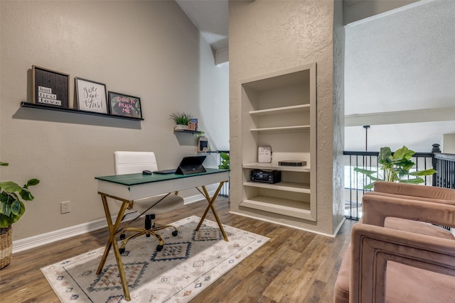 home office with built in features, baseboards, and wood finished floors