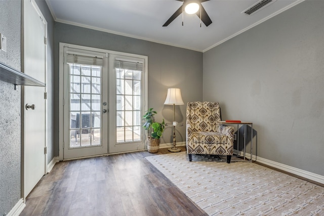 sitting room featuring wood finished floors, visible vents, baseboards, french doors, and crown molding