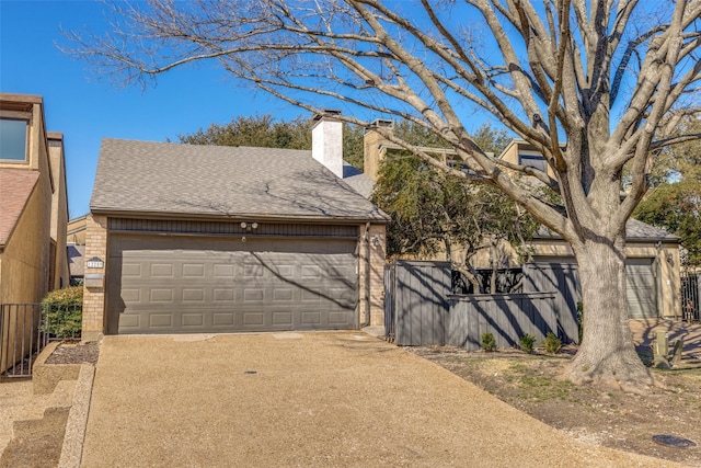 garage featuring driveway and fence