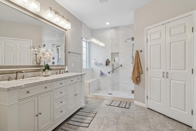 full bath featuring double vanity, walk in shower, and a sink