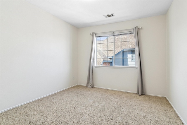 carpeted spare room featuring baseboards and visible vents