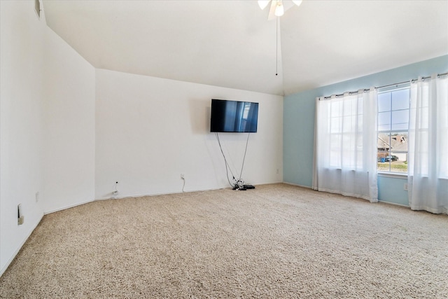 empty room featuring vaulted ceiling, carpet floors, and ceiling fan