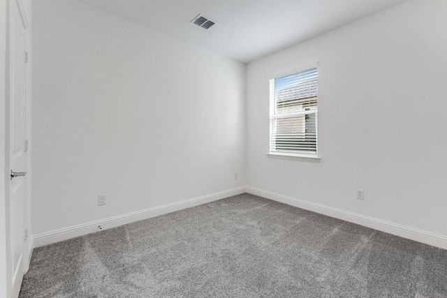 spare room with baseboards, visible vents, and carpet flooring